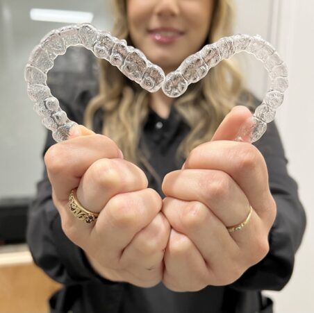 Clear aligners held in a heart shape