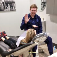 a dentist talking to a child laying in the patient chair in a dentist office in Cary